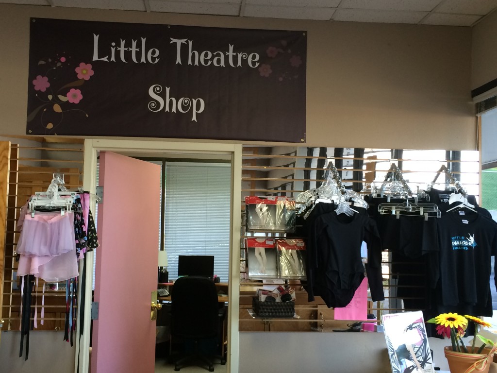 A little theatre shop with clothes hanging on the wall.